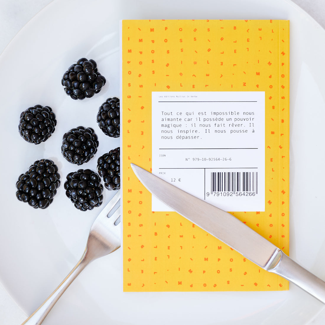 Le livre est retourné dans l'assiette avec des mures. On peut lire la quatrième de couverture.